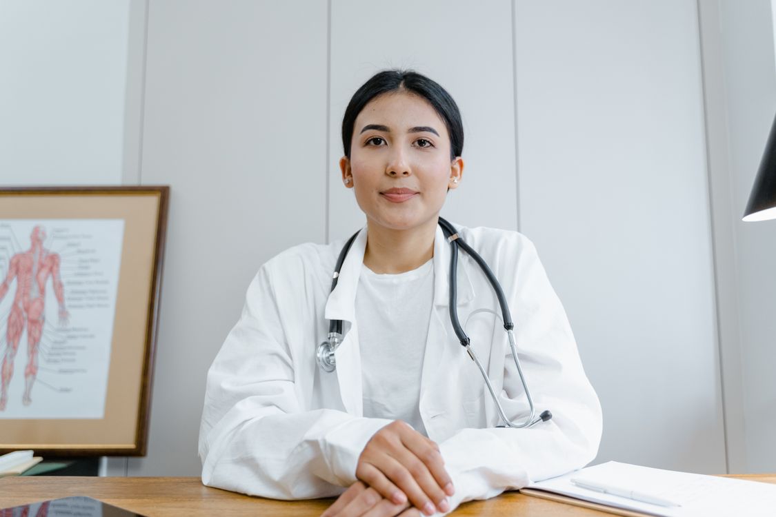Medical student in white coat reviewing anatomy — medical school program